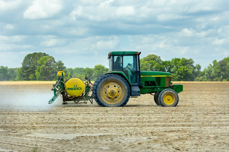 Ein Traktor versprüht Pestizide auf dem Feld