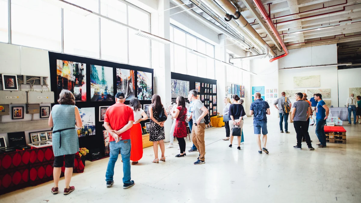 Viele Personen in einem Industriegebäude betrachten eine Ausstellung