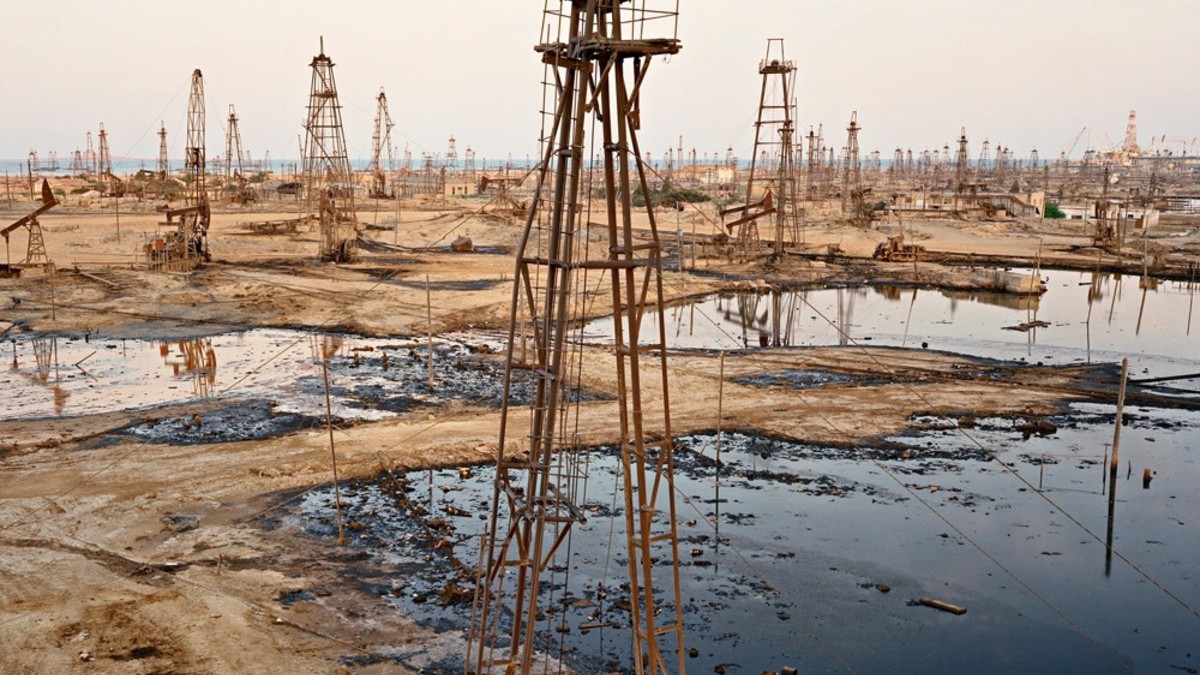 Ein Areal voll mit alten Bohrtürmen und Ölfeldern, welche mit Öl überschwemmt sind.
