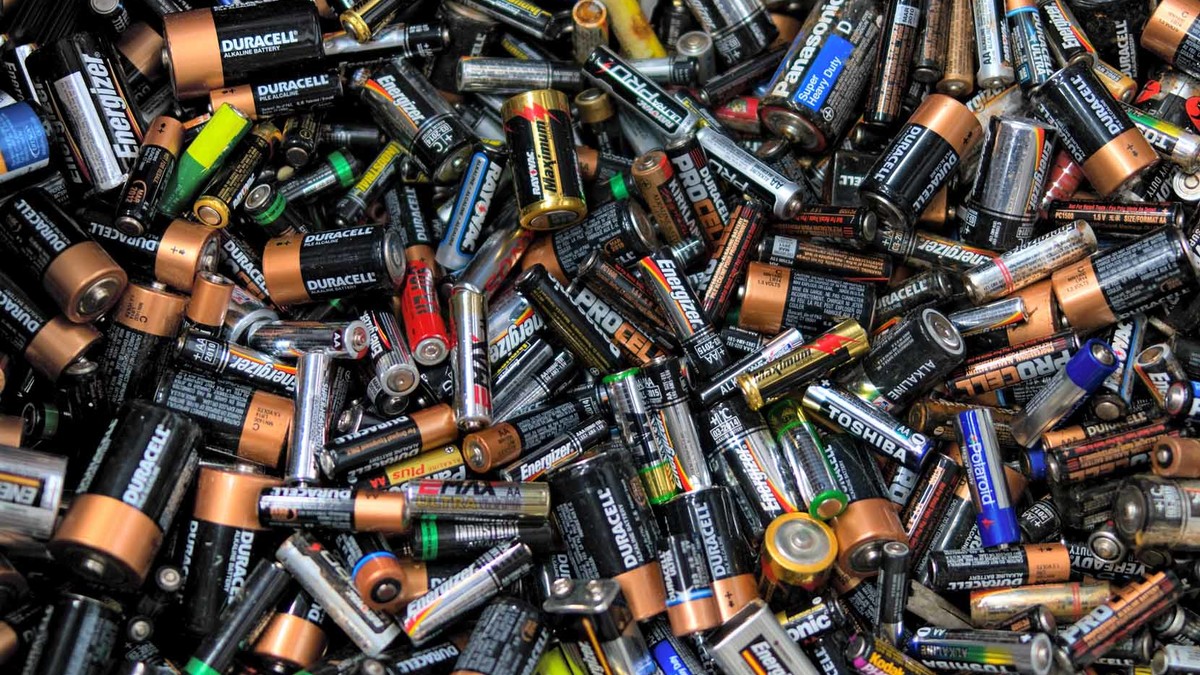 Zahlreiche alte Batterien liegen auf einem Stapel.