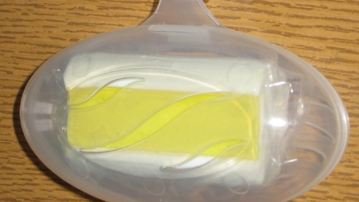 Gelber Duft-WC-Stein in Plastikbehälter