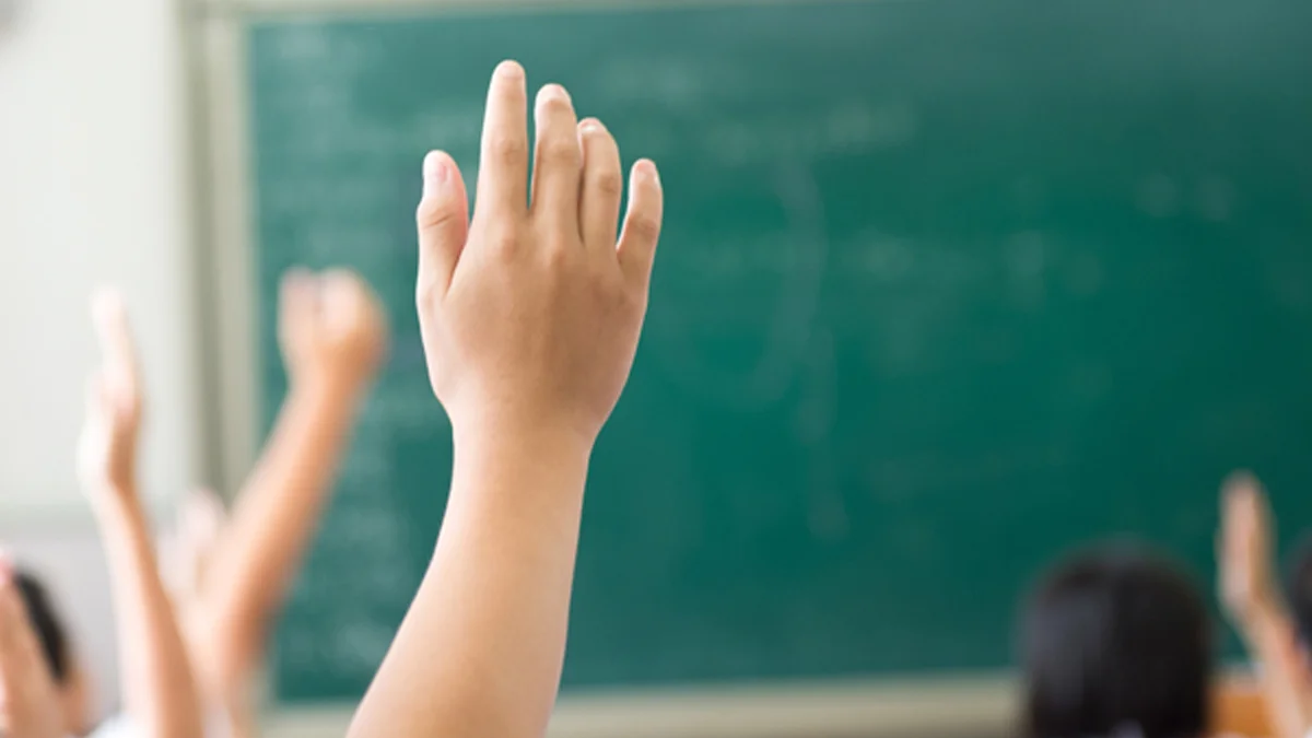 Kind meldet sich im Schulzimmer