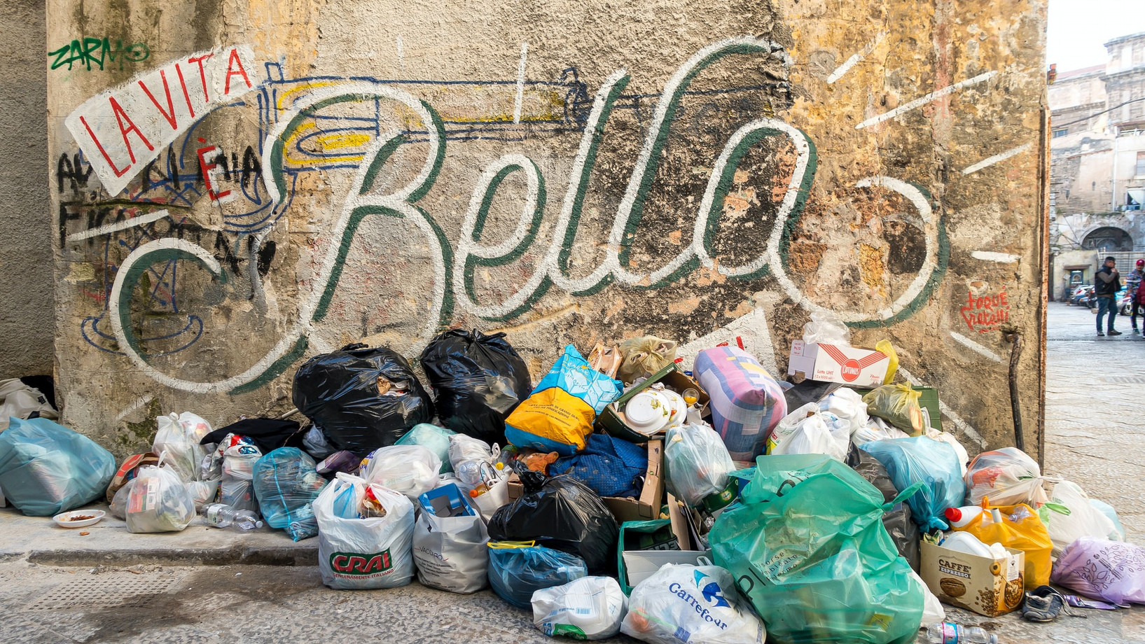 Müllberg vor Hauswand mit dem Graffiti "La vita Bella"