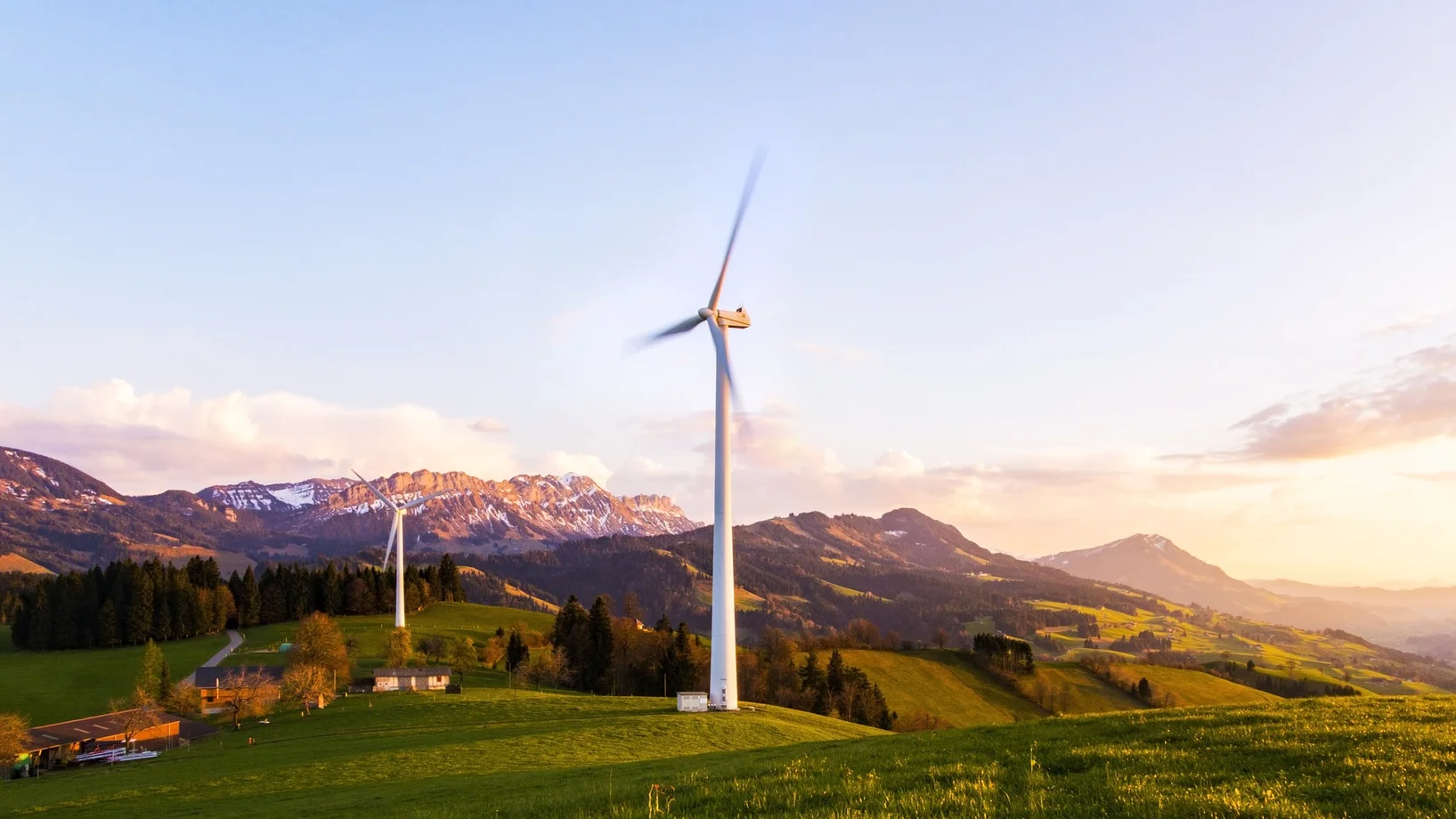 Zwei Windräder auf Wiese. Im Hintergrund die Pilatuskette.