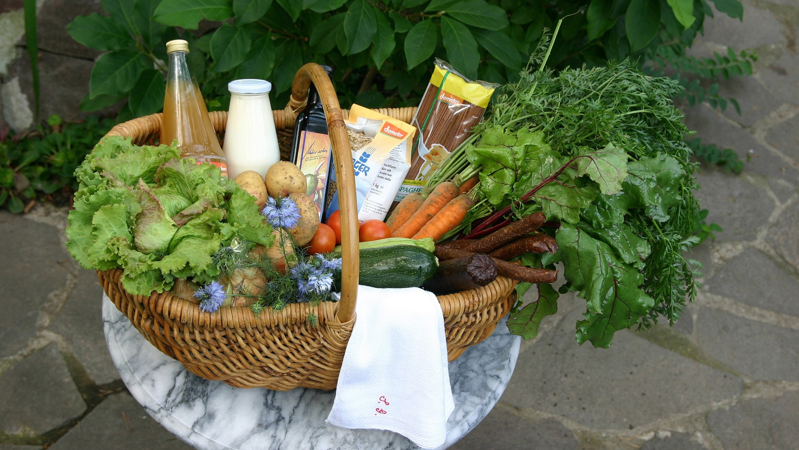 Ein Korb gefüllt mit Bio-Gemüse, Milch und Saft