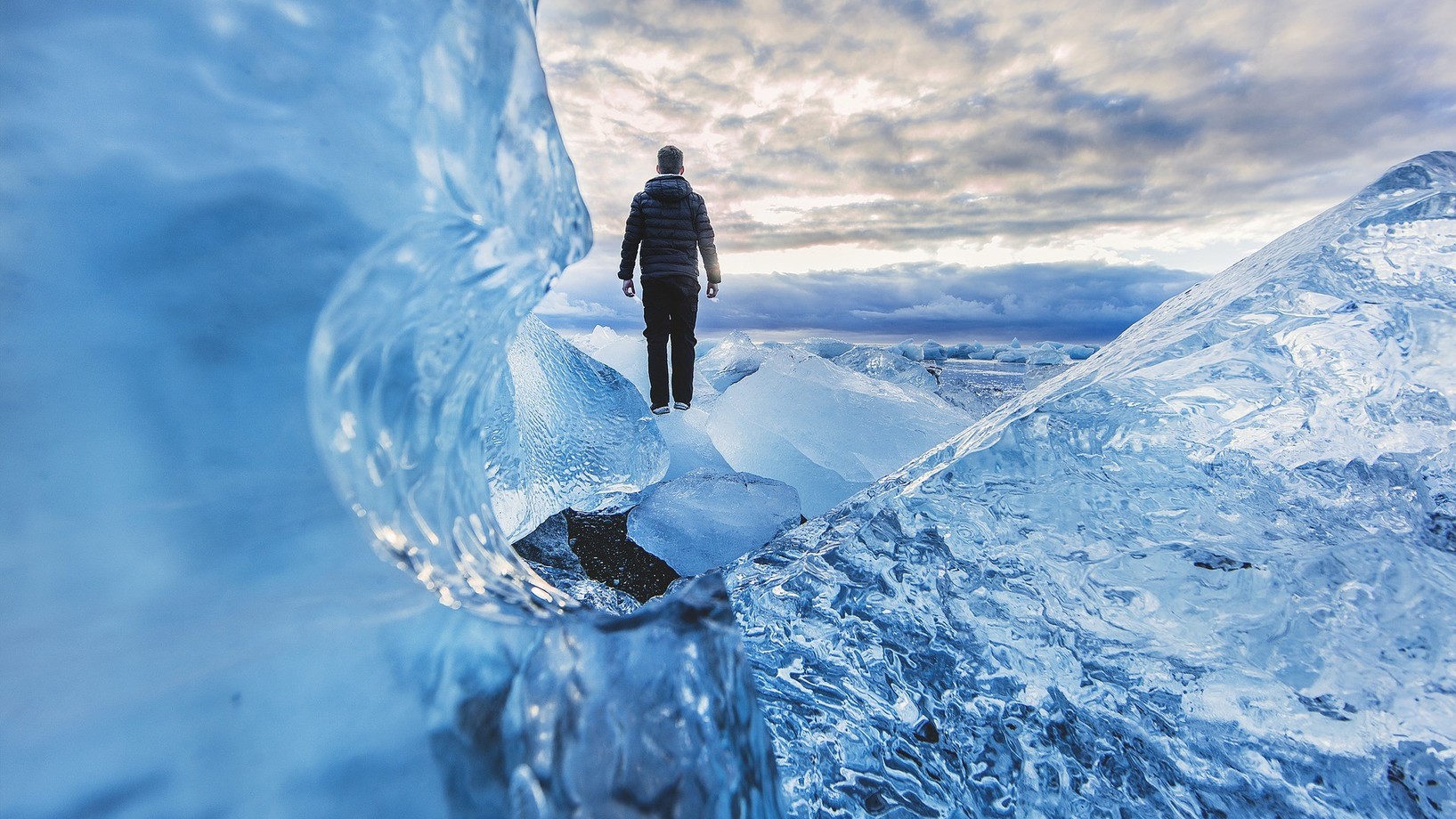 Ein Mensch steht inmitten von riesigen Eismassen. 