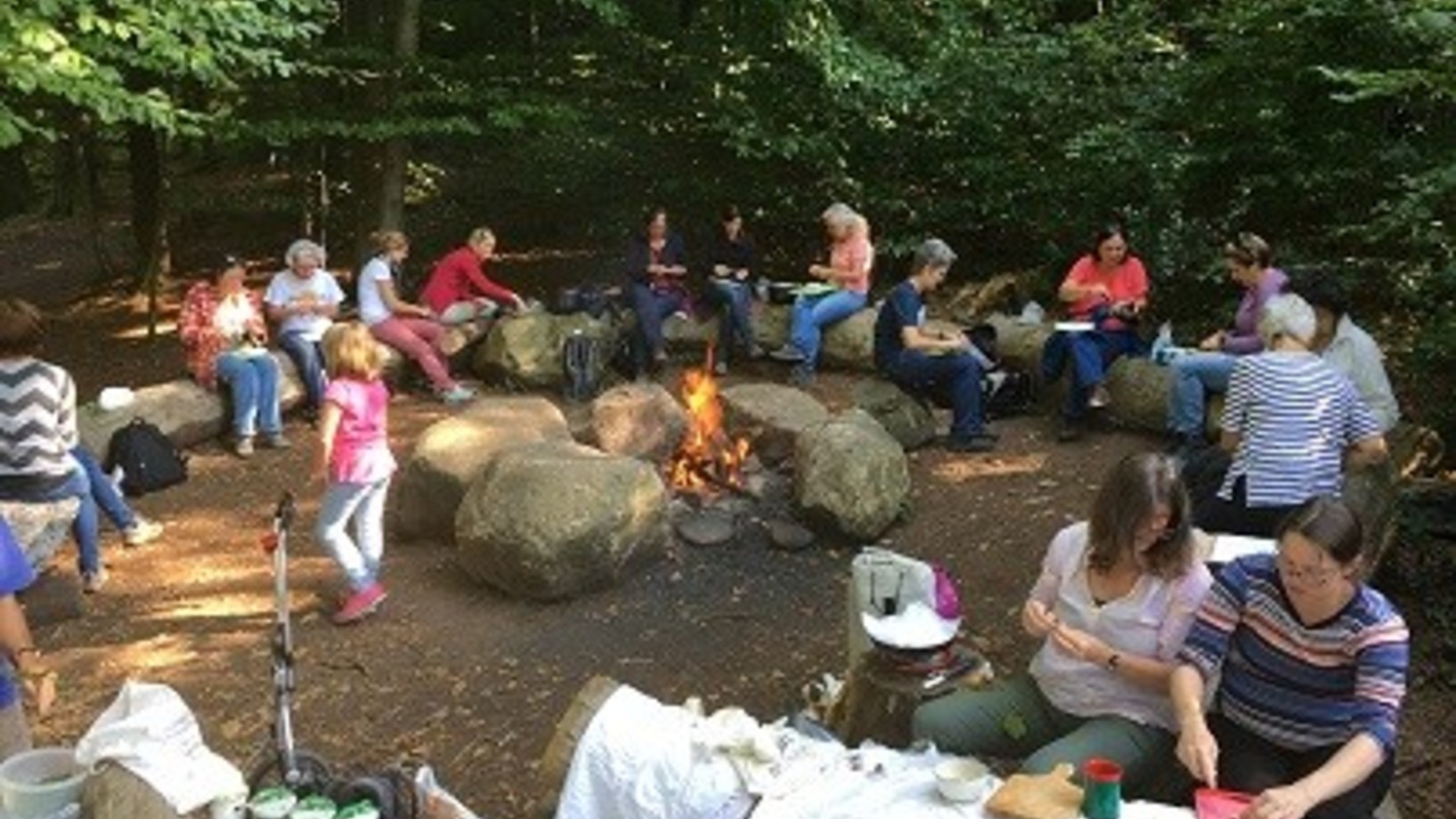 Menschen im Wald, beim Zubereiten der Suppe über dem Feuer.
