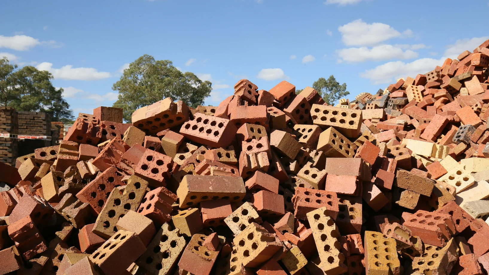 Heap of red broken bricks in construction area
