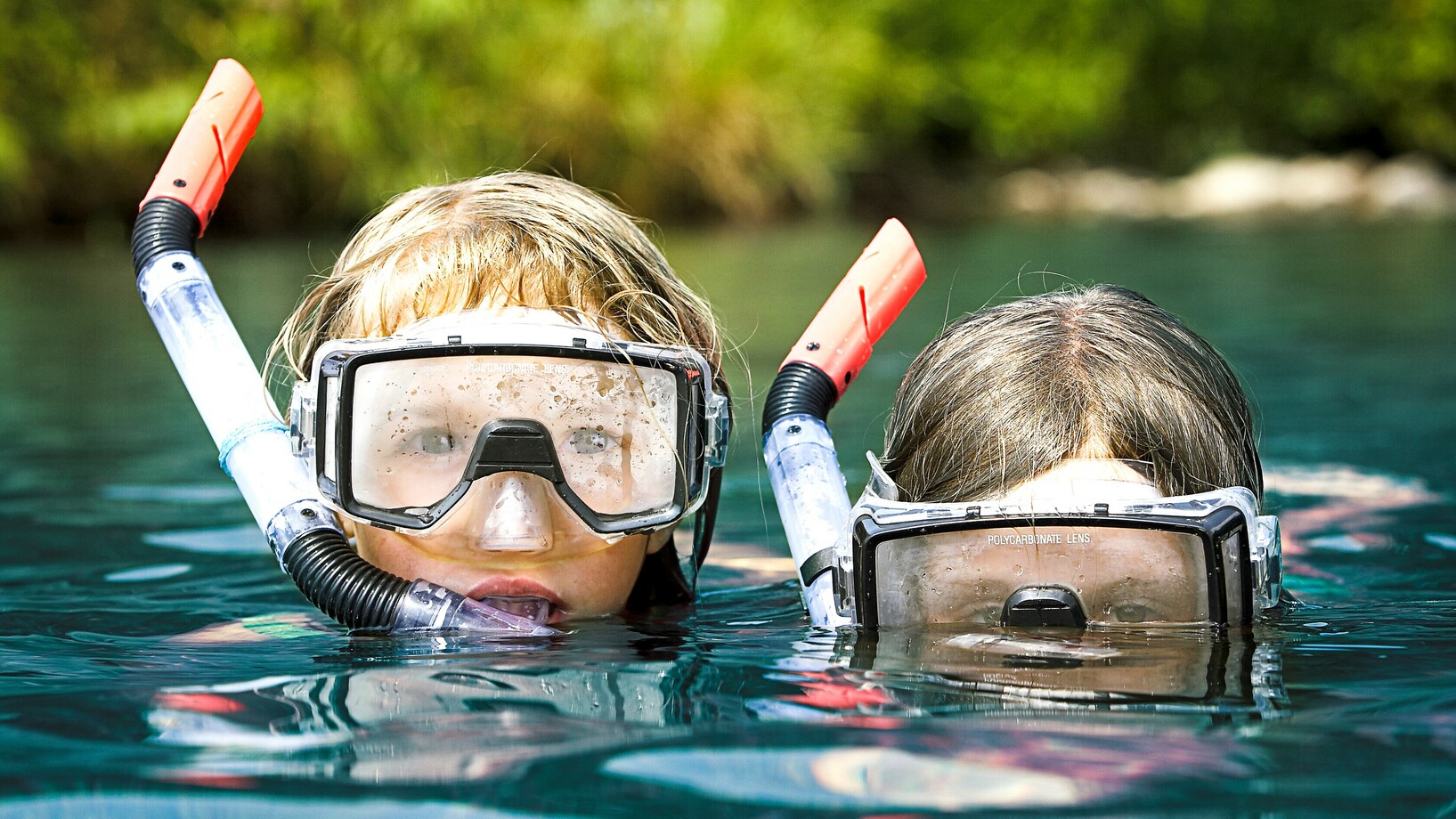 Zwei Kinder mit Schnorchel und Taucherbrille im Wasser