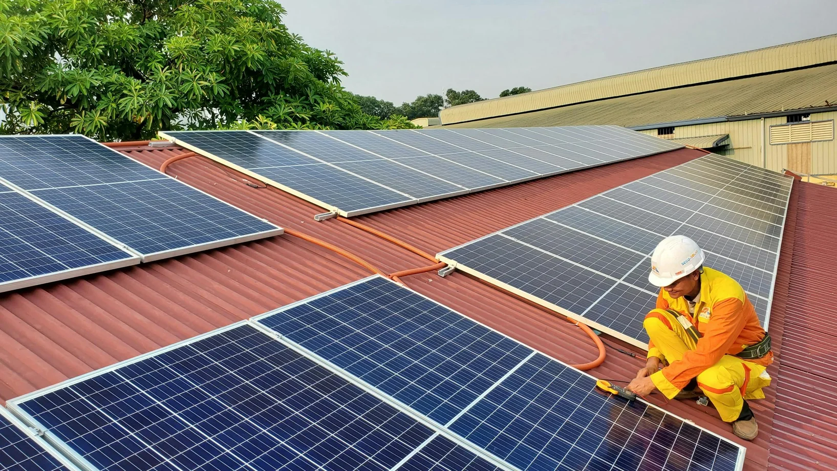 A solar technician performs maintenance on rooftop solar panels enhancing energy efficiency.