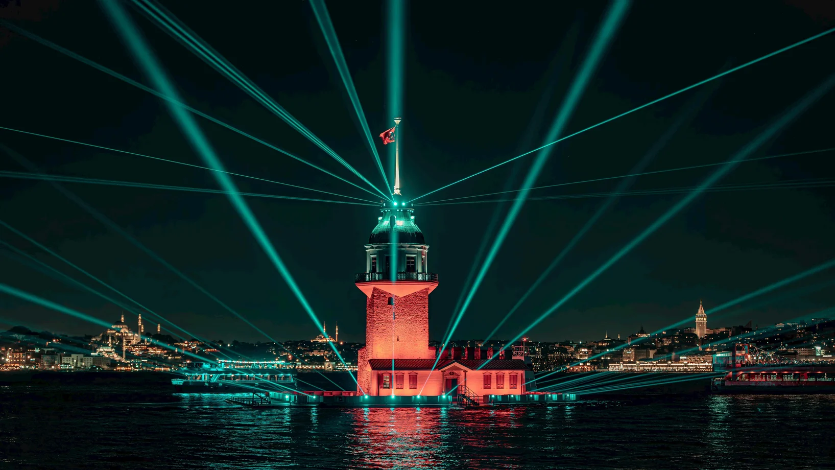 Captivating view of Maiden's Tower in Istanbul with vibrant laser lights at night. Perfect for travel and city exploration themes.